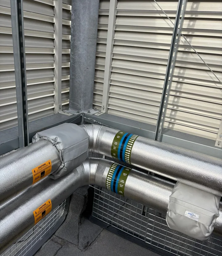 Completed chilled-service pipework with stucco cladding and access-friendly insulation jackets
