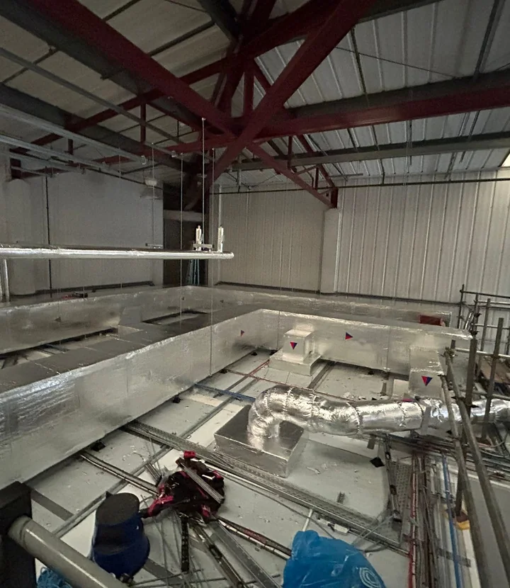 Completed mineral-wool ductwork insulation across a commercial ventilation route