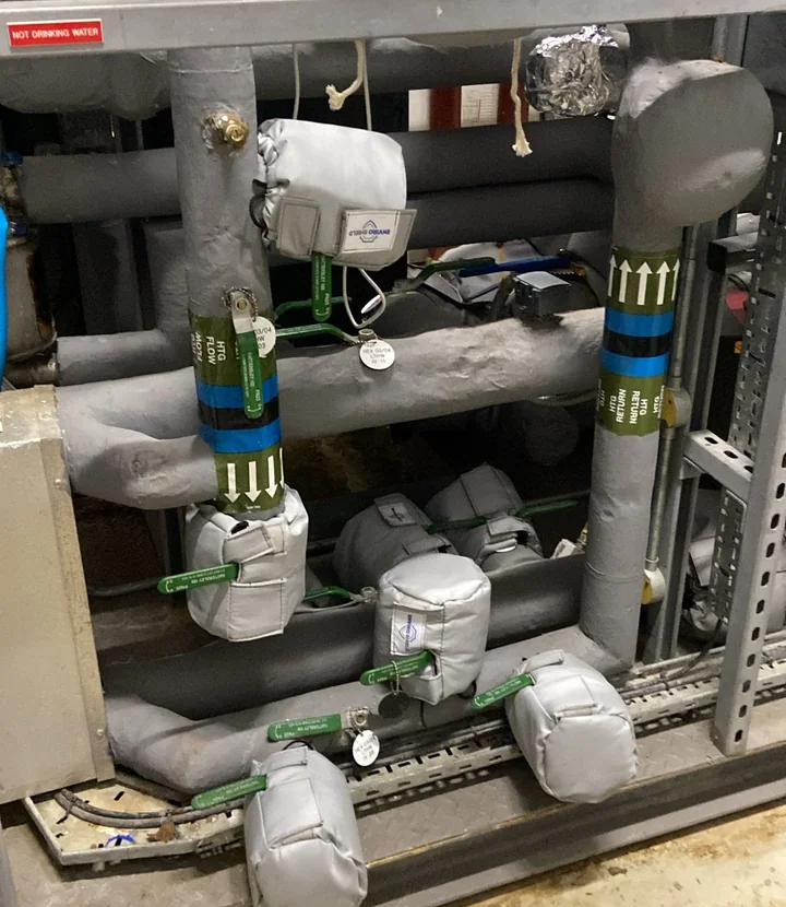 Removable insulation jackets fitted around valves and fittings in a commercial plant room