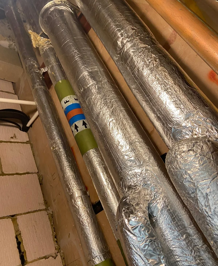 Finished insulated pipework inside an industrial plant area
